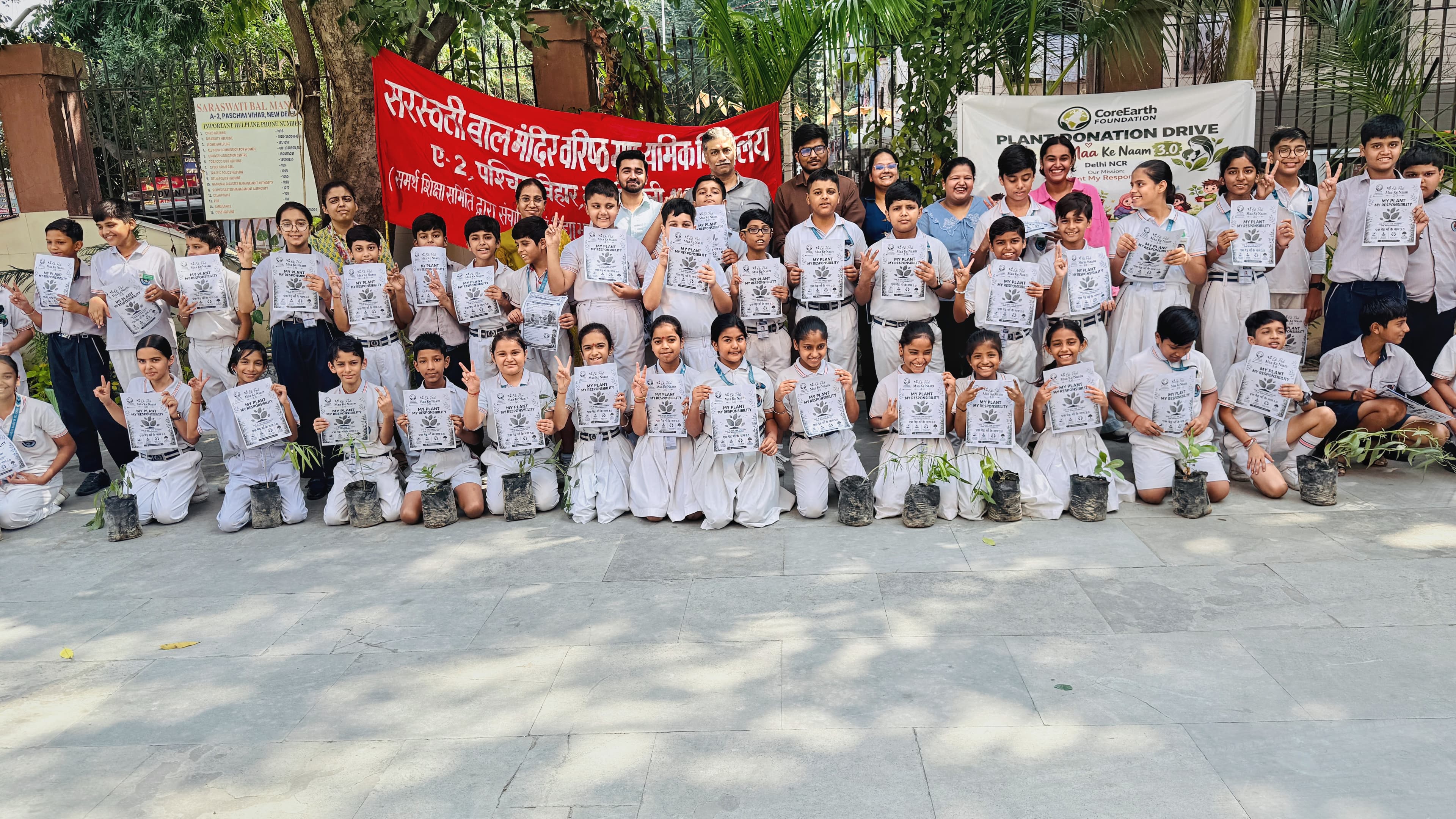 Students at Saraswati Bal Mandir, Delhi, holding saplings and pledge cards at a CoreEarth plant donation drive