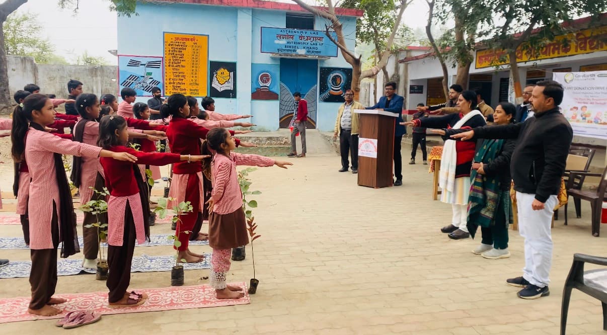 Students take the plant-care pledge, sapling in hand, at a school plantation drive in Mahoba.